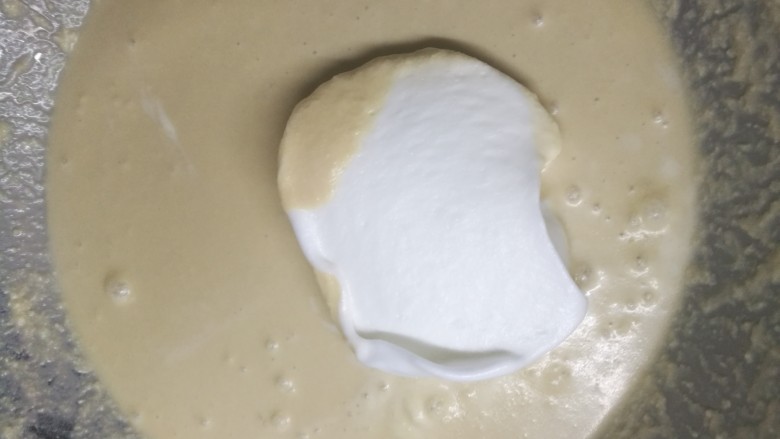 咖啡味神奇魔法蛋糕,先取一小部分蛋白糊加入到面糊中,切拌均匀后,分次加入其他蛋白糊。