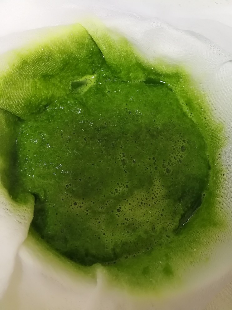 蒸斑斓椰香戚风蛋糕,取一块纱布放在盘子里,倒入斑斓渣汁,纱布包起来过滤拧出汁液。