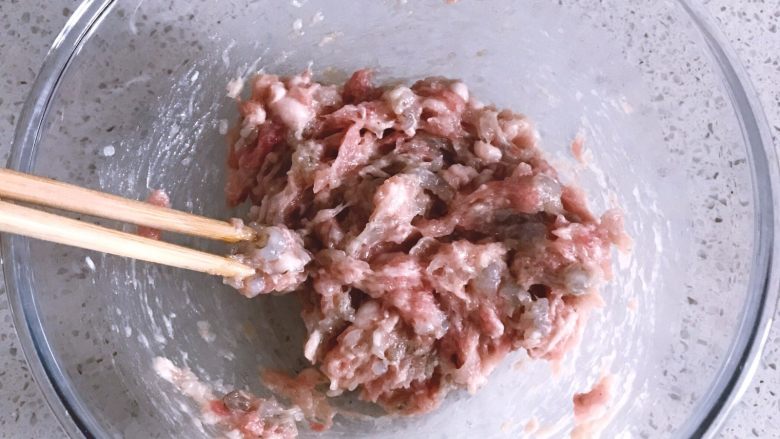 鲜虾时蔬小馄饨,倒入除虾油外的所有材料,用筷子顺着一个方向搅拌肉馅,直至肉馅出筋的状态