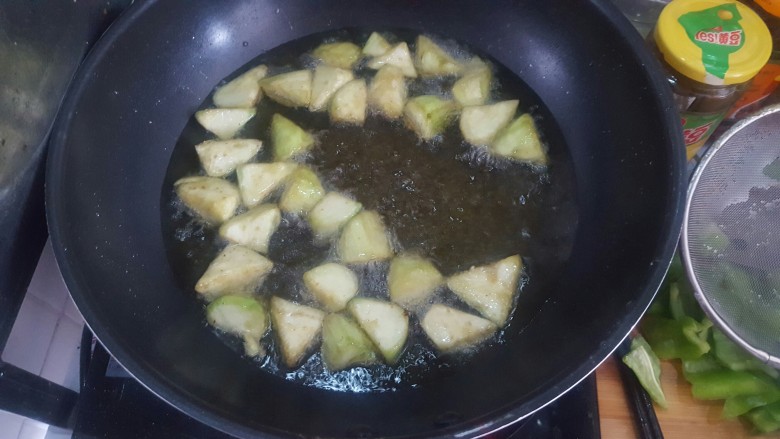 美味地三鲜,油热后放入茄块,炸到翻黄的时候就可以捞出来了