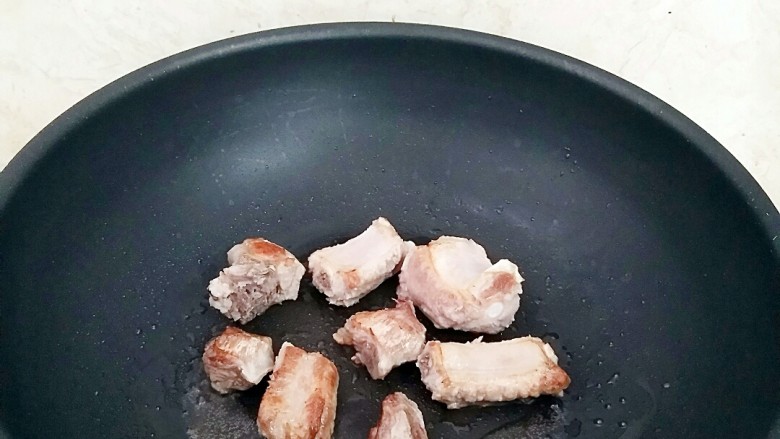 玉米粒排骨焖饭,锅中放油2汤匙,放入排骨煸炒出油。