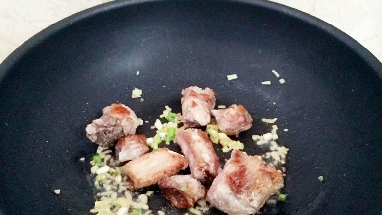 玉米粒排骨焖饭,放入葱,姜翻炒出味。