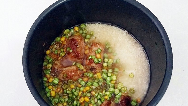 玉米粒排骨焖饭,所有的食材倒入电饭煲中,加入清水,水量刚好莫过食才,开启焖饭模式。