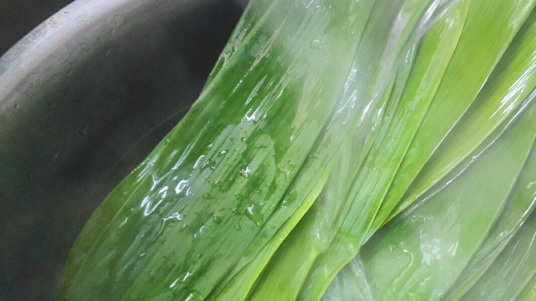 彩米花生香菇肉粽,最后再用热水冲洗,这样洗干净了,粽叶经过高温包时不易裂开。