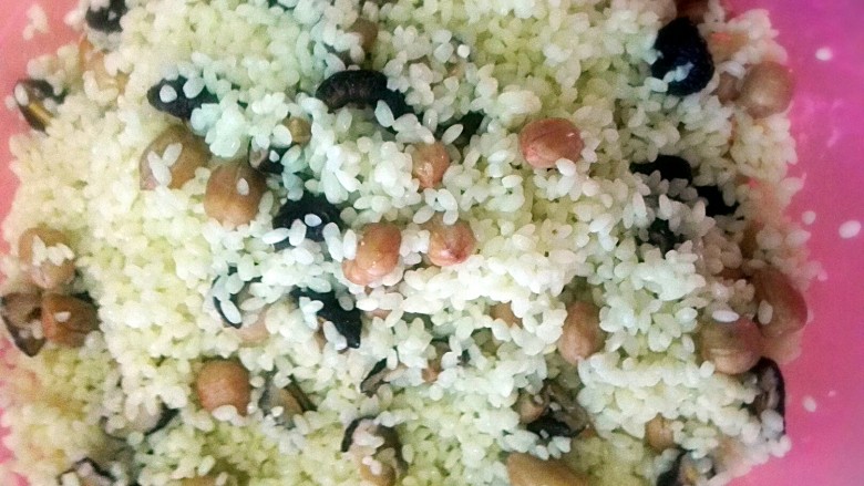 彩米花生香菇肉粽,加入泡好的花生,香菇,加适量盐和腌制肉的汁倒进去,用手抓均匀。