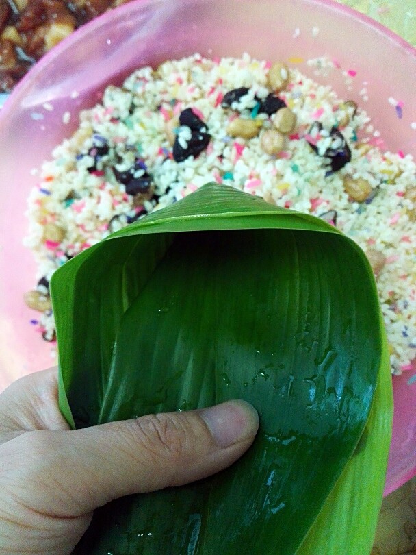 彩米花生香菇肉粽,两只手朝着自己往里弯一下,就成这样了。