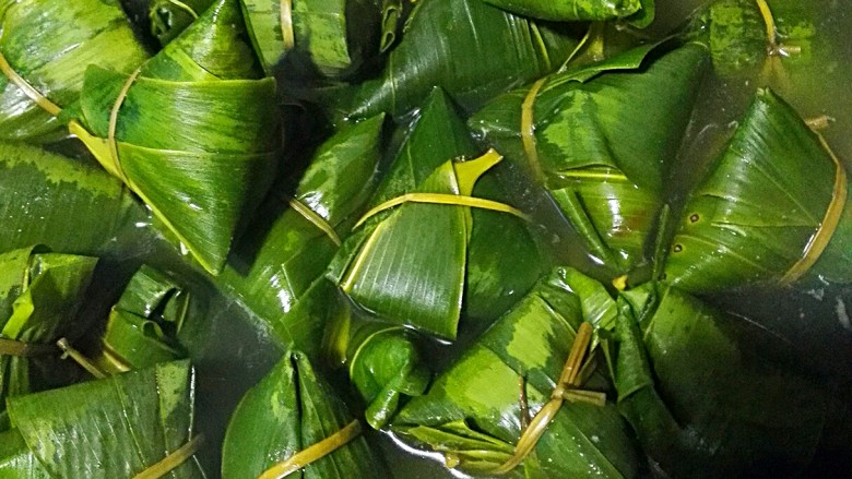彩米花生香菇肉粽,焖到水不烫为止,一串串取出来沥干,就可以吃了。