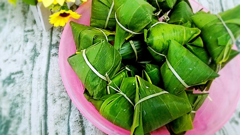 彩米花生香菇肉粽,这样一个个用绳子绑好，绑绳/棉线扎紧，尽可能的扎紧一些，友友们不懂并排绑，可以一粒粒绑， 并修剪绳子的头和粽叶多出来的部分，这样比较美观。