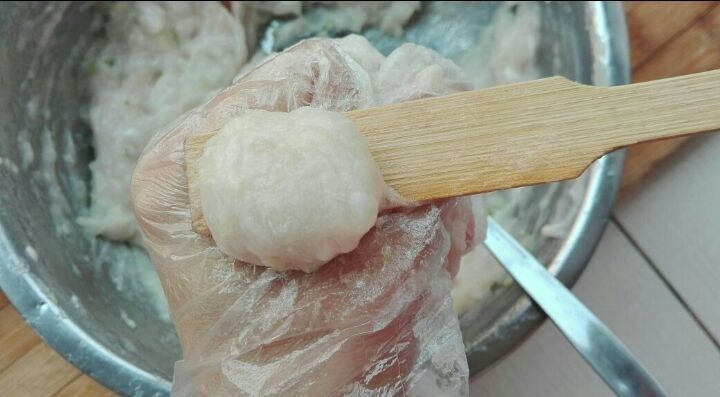 鱼丸,用勺子或其它工具将虎口挤出来的丸子,刮下来,放入提前备好的冷水盆里