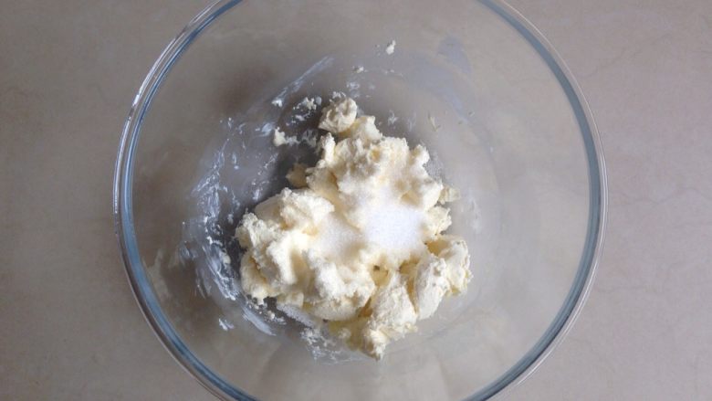 蔓越莓奶酪面包,在等待发酵的时间制作奶酪馅,碗里放入切成小块的奶酪,隔热水软化,加入糖。