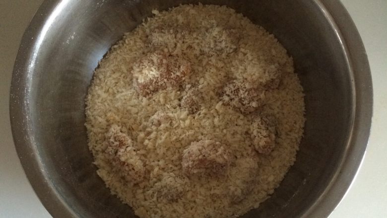 芝加哥香酥鸡米花,把鸡肉放入面包屑中,摇晃盛器,让鸡肉快速均匀的裹上面包屑