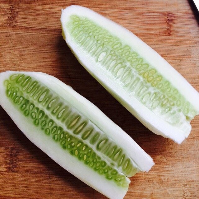 凉拌榨面,把黄瓜一切二,这时我们要把籽去掉,不去掉的话会影响口感