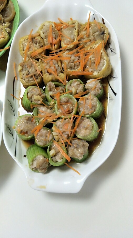 客家酿丝瓜豆腐,做好后可以用蒸的,也可以煎一下用水焖,建议用焖,比较好吃。
焖好后起盘,然后把<a style='color:red;display:inline-block;' href='/shicai/ 2794'>大蒜</a>沫爆炒一下,用水加生抽一起煮,把煮好的汁淋到上面,再撒点胡萝卜丝装扮一下,或者用葱花,按自己喜欢的来