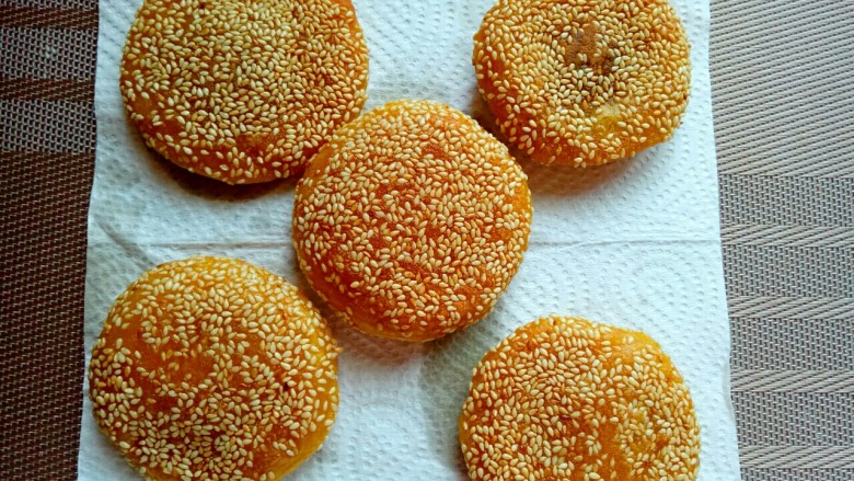 芝麻南瓜饼,煎好的南瓜饼放在一张油纸上,吸掉油腻。