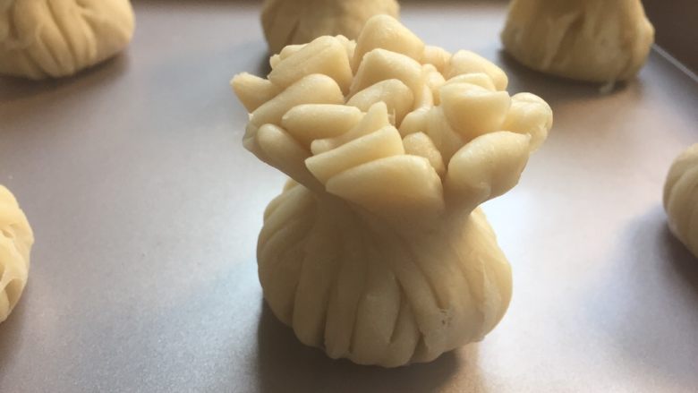 红豆沙花朵酥,收口后码入烤盘,顶端刷上蛋黄
