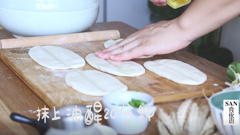 陕西油泼面,然后将面团揉成条状,擀成椭圆面皮,中间压一道,抹上食用油,醒发20分钟