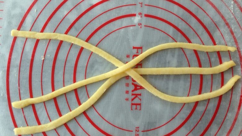 编织苹果派,将其他派皮也擀薄,切出三条0.8 cm宽28 cm长的长条,如图在中间交叉摆放