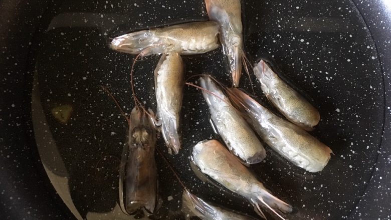秘制鲜虾粥,热锅放油,放虾头,小火煸出虾油,用铲子压一压虾头