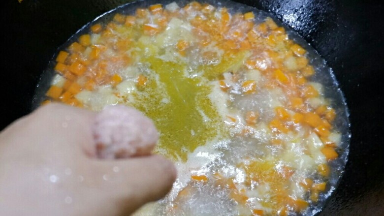 三丁肉丸粉丝汤,然后就可以挤肉丸进去锅里了。肉馅抓手里,用虎口位置挤出