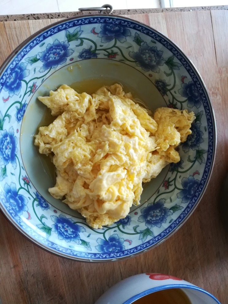 韭苔炒鸡蛋,油热后倒入鸡蛋,成形后迅速铲出备用