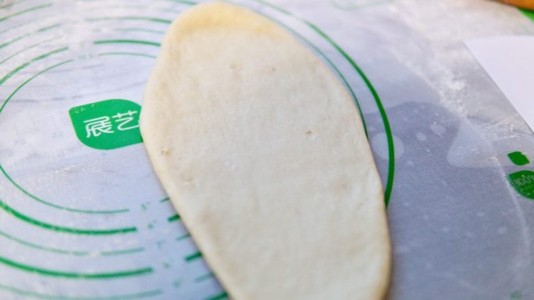 蜜豆吐司,取一个面团,擀开成舌头状
