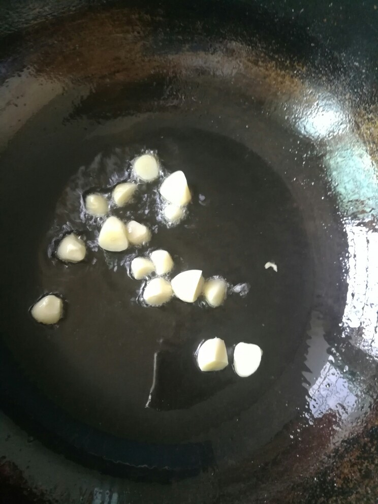 辣椒青豆炒鸡丁,坐锅热油,下蒜粒煸香。