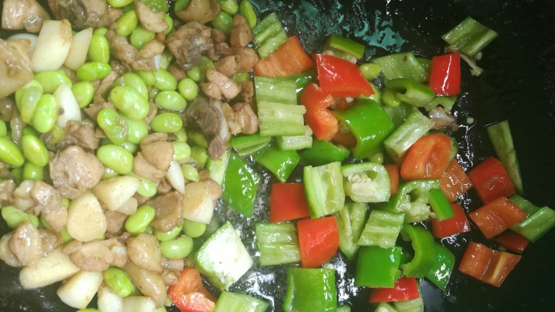 辣椒青豆炒鸡丁,将炒过的扒在一边,下辣椒块先单独炒半分钟。