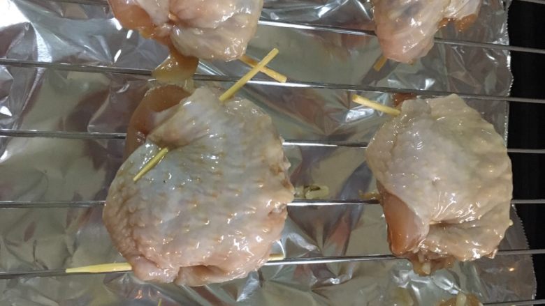 鸡翅包饭,把饭塞到鸡翅里,两头用牙签固定,烤箱预热,180度烤半个钟