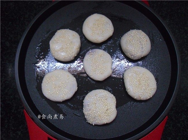 芝麻紫薯馅煎饼,电饼铛通电加热，上下盘刷一层食用油，将包好的馅饼码在煎盘内