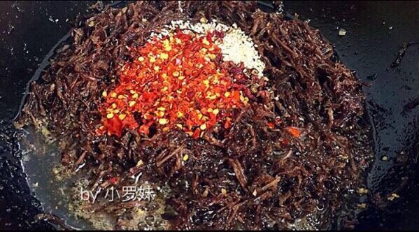 麻辣牛肉丝,最后放入花椒,辣椒面,花椒和辣椒面一定要放最后,因为花椒和辣椒面比较容易糊。再添加鸡精,白芝麻翻炒均匀出锅!