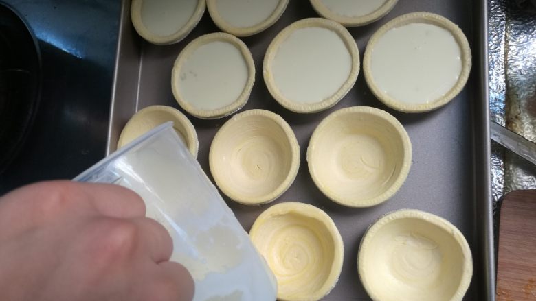 烘焙小白零失败的——黄桃蛋挞,搅拌均匀后倒入蛋挞皮内,每个七八分满即可。