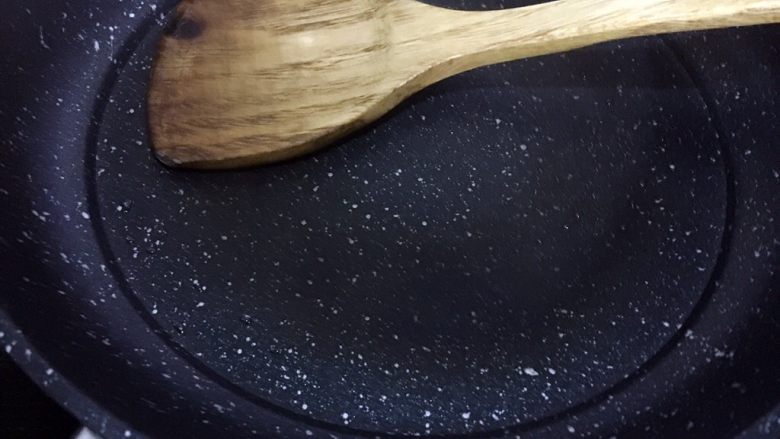 芹菜叶鸡蛋饼,用铲子背面将油均匀抹开,使锅底有薄薄的一层油