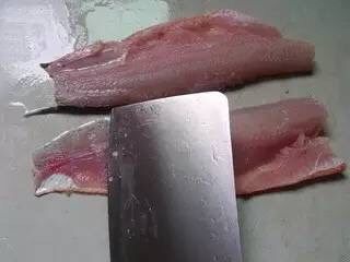 酸菜鱼,鱼肉块洗干净血污,下面放一块洗碗布,刀斜大概40度左右,从尾部开始开片鱼,方向是刀刃朝向尾部,开成鱼片