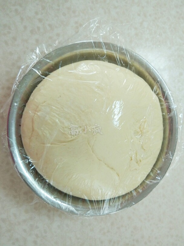 香葱肉松花卷,和出带有扩展性光滑的面团,放到盆里盖上保鲜膜,进行发酵2.5倍大。
