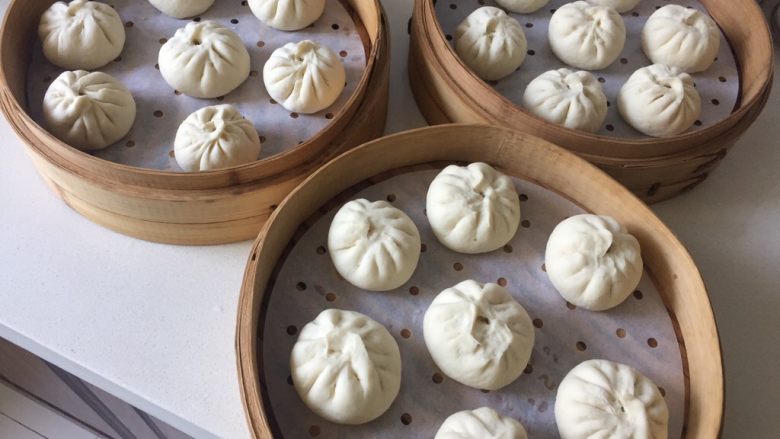 鲜肉包子,蒸屉垫上油纸或纱布,包好的包子放在油纸上,包子之间要留出一定的间距,包子在蒸的过程中会变大。