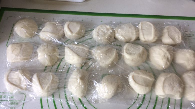 鲜肉包子,案板上撒少许面粉,面剂子盖保鲜膜静置醒发15分钟。