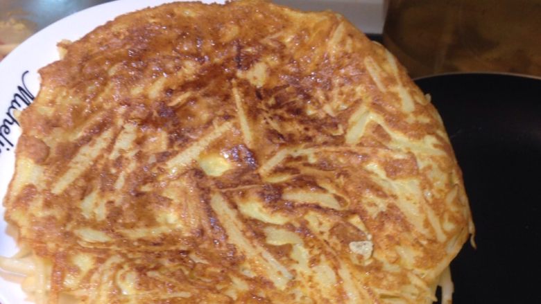 馬鈴薯煎餅,將煎餅倒扣在盤子上,再利用盤子將已翻面的煎餅另一面滑入平底鍋一樣煎到金黃酥脆