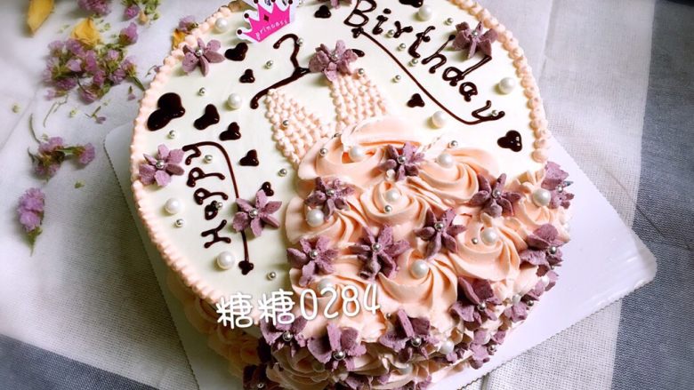 小花裙蛋糕,最后用甘纳许写上“HappyBirthday”，并画小爱心装饰表面