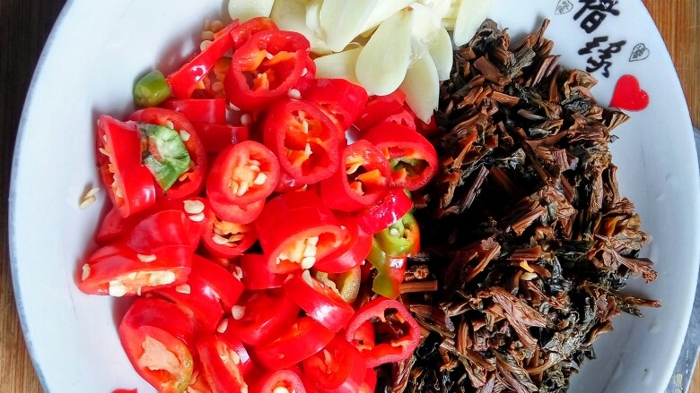 豆豉酸菜炒苦瓜,蒜子切片,红椒切圈或碎片都行。干酸菜泡水回软后也切碎。