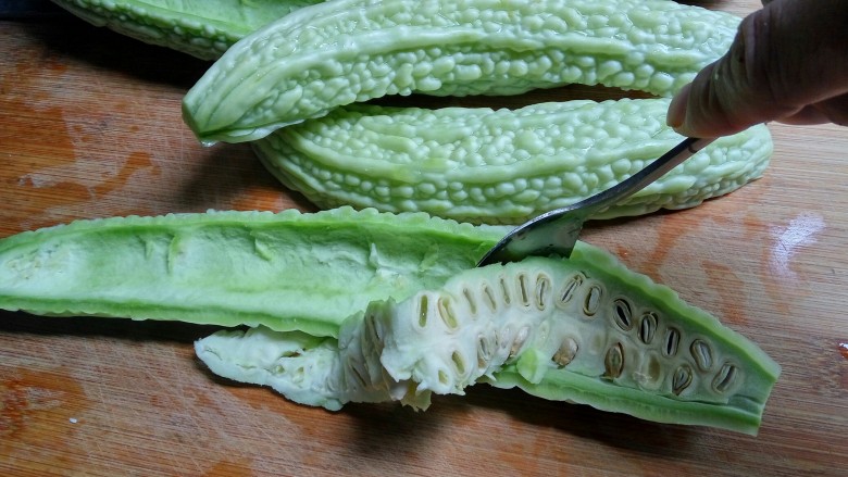 豆豉酸菜炒苦瓜,苦瓜对半剖开后,用汤勺一挖,苦瓜的瓤和籽就很干净的去除了。