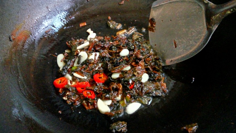 豆豉酸菜炒苦瓜,油烧热后,先把蒜子,浏阳豆豉,干酸菜,红椒依次下锅稍微煸炒。