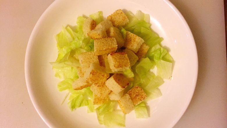 焦香面包小丁,把烤好的面包小丁放在生菜上边;