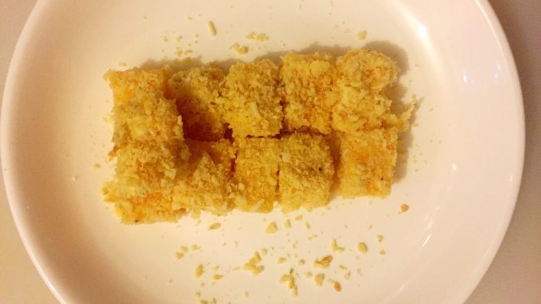 浪漫五色红薯小方,把拌匀的红薯小方丁蘸上苏打饼干碎,动作要轻一点,像爱护自己的眼睛样;不然容易碎的,红薯蒸熟后容易变形;