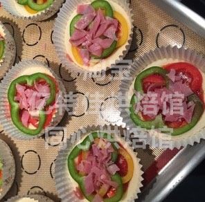 自制迷你披萨,然后放两片彩椒切片，彩椒不要切得太厚，太厚不容易烤熟还会出水，再撒上火腿切片