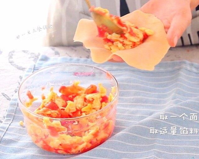 番茄鸡蛋馅饼,将晾凉的鸡蛋和番茄泥混合在一起。取一个面皮放左掌心,取适量馅料放入面皮中央。
🌻小贴士:先擀皮再调馅,馅调的太早,容易出汁不好包。