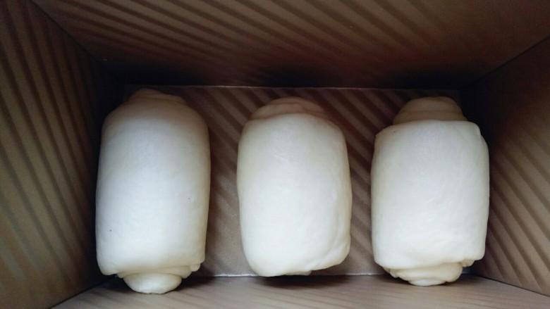 蔓越莓吐司面包,做好的面团卷,接口朝下整齐放在吐司磨具里,我的磨具是450g的吐司磨具。
