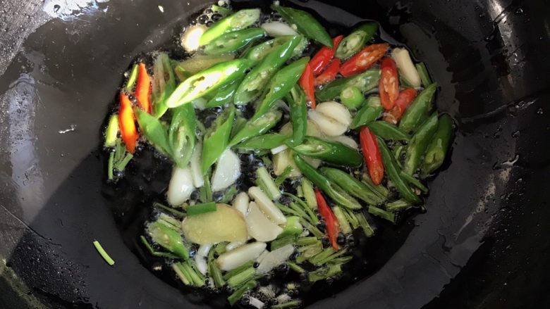 爆炒香辣花蛤~好吃到爆,锅烧热放入适量的油,葱姜蒜爆香倒入辣椒翻炒出辣味