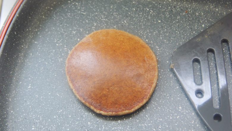 【燕麦香蕉Pancake】(素食低脂版),翻面的时候铲子要快一点,基本把整个面饼铲到再迅速翻面。翻面后再小火加热1到2分钟到面饼熟了就做好啦