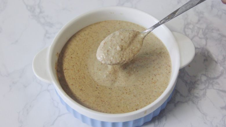 【燕麦香蕉Pancake】(素食低脂版),榨汁机中加入所有食材后,最后倒入香蕉泥。搅打好的面糊干稀合适,也打得很细腻。盛到一个大碗中备用。