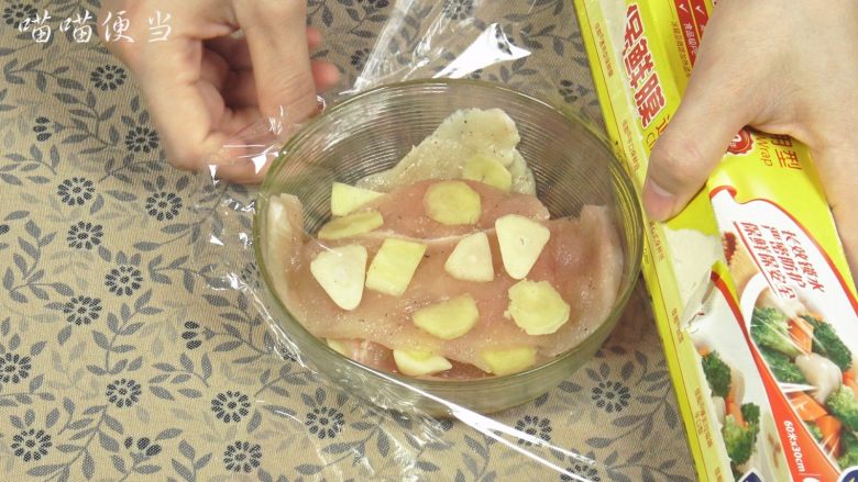 香煎鸡排饭,然后将鸡肉放入碗里,加入大蒜跟姜片,盖上保鲜膜,放入冰箱冷藏一个小时左右。